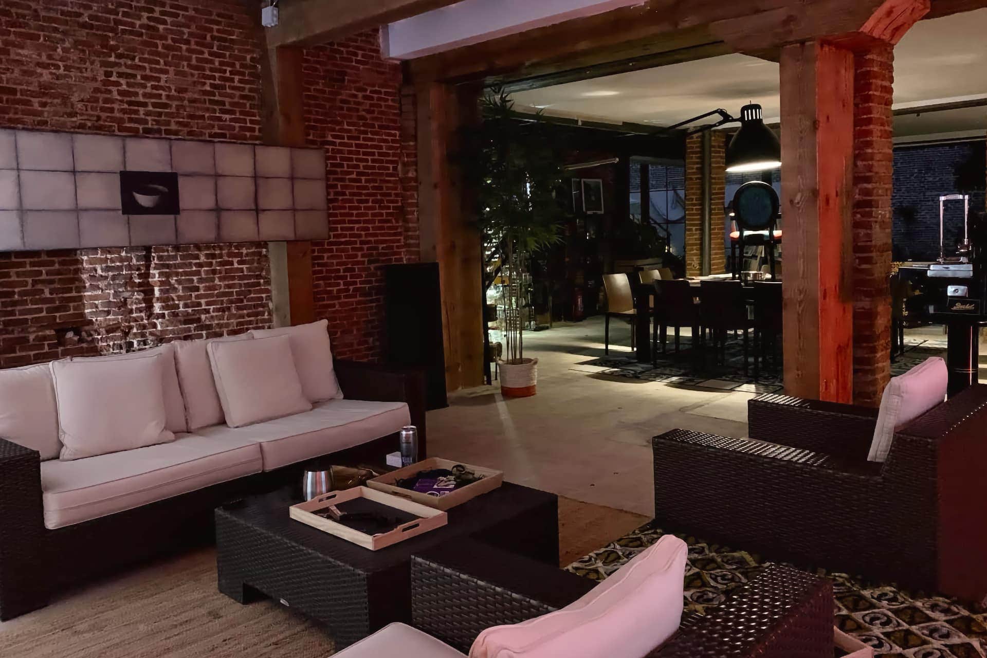Moderner Loungebereich im Madrid Noviciado cannabis-club mit Backsteinwänden und Rattansofas