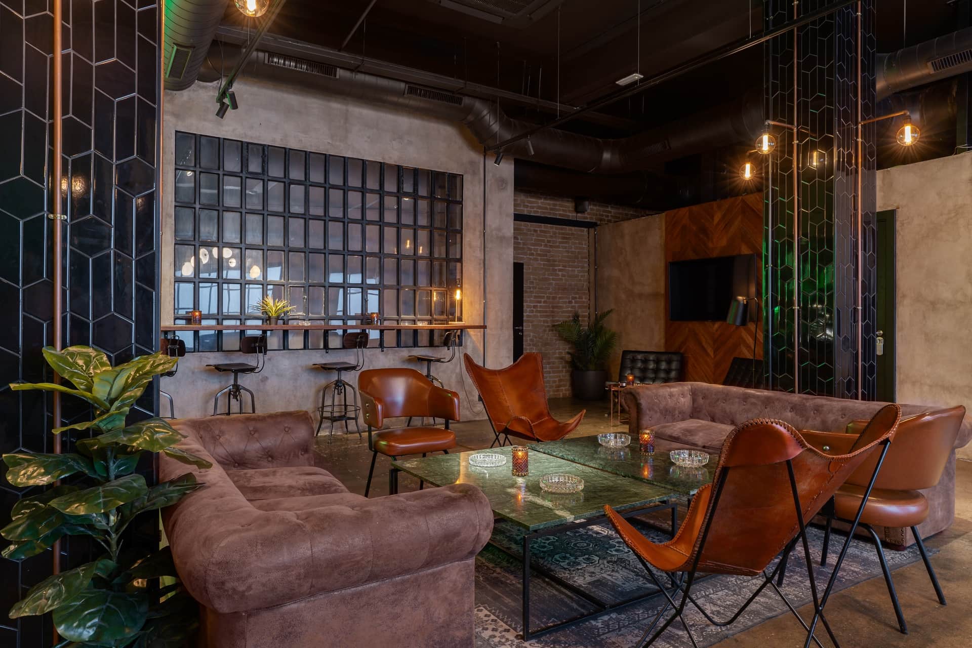 Dr. Resin Barcelona Cannabis-Club — moderner Lounge-Bereich mit braunen Sofas, Glastischen und grünen Pflanzen