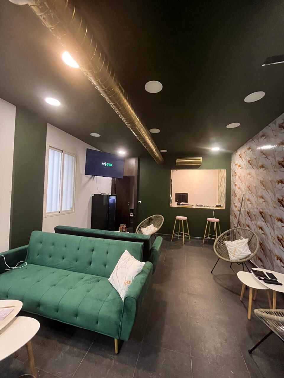 Hauptraum des Cannabis-Clubs Green Paradise in Madrid mit grünen Sofas