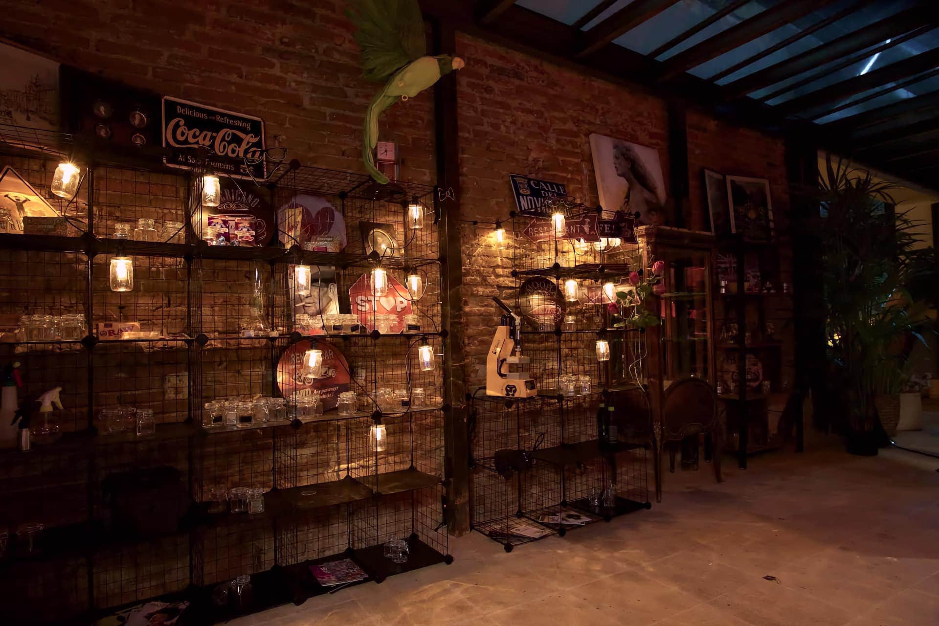 Regale mit Retro-Dekoration und warmem Licht im Noviciado cannabis-club in Madrid